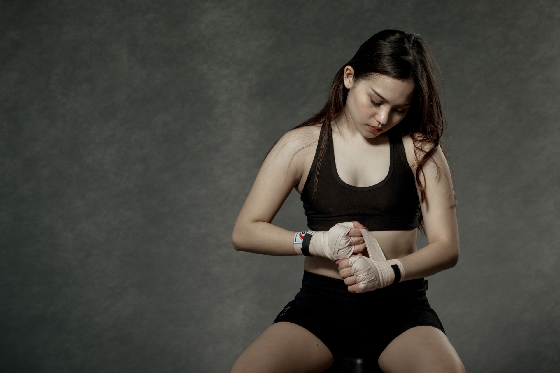 A fighter preparing hand wraps before training